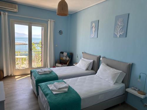 two beds in a room with a view of the ocean at Akroyali Hotel & Villas in Agios Andreas