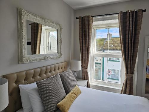 a bedroom with a bed with a mirror and a window at Brogans Bar & Hotel in Trim