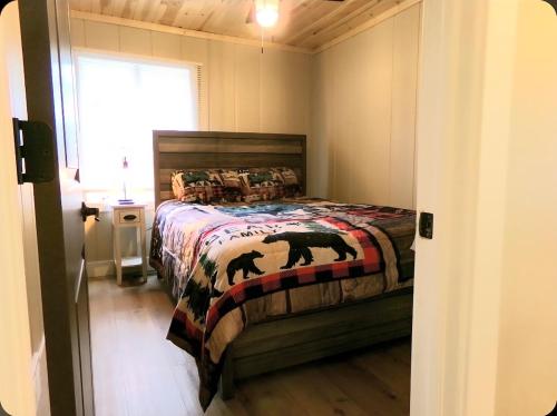 a bedroom with a bed with a bear blanket at Cookie's Cottage in Caseville