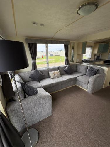 a living room with a couch in a van at Golden Palm Resort Meadow Lakes 3 bedroom 8 berth in Chapel Saint Leonards