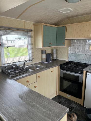 a kitchen with a sink and a stove at Golden Palm Resort Meadow Lakes 3 bedroom 8 berth in Chapel Saint Leonards