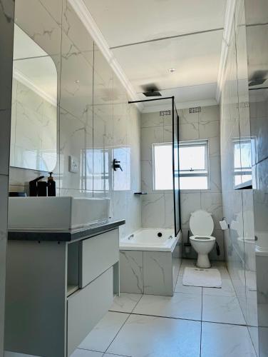 ein Badezimmer mit Badewanne, Toilette und Waschbecken in der Unterkunft Cingar Suites in East London