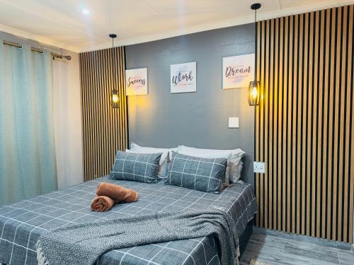 ein Schlafzimmer mit einem Bett, auf dem ein Stofftier liegt in der Unterkunft Cingar Suites in East London