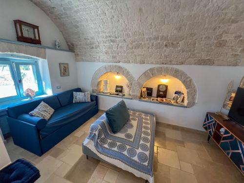 a living room with a blue couch and a table at Trullo Dimora Podere Papilio in Noci