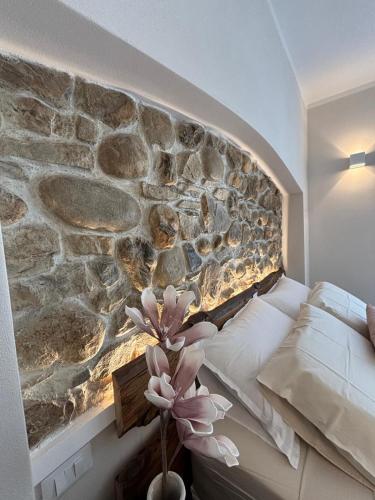 a bedroom with a stone wall next to a bed at HH Moneglia La Caletta in Moneglia