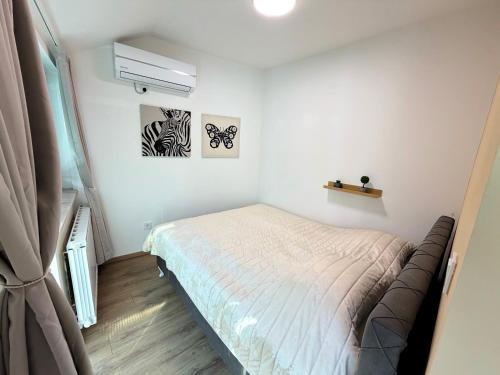 ein kleines Schlafzimmer mit einem Bett und einem Fenster in der Unterkunft Soni Trg in Tuzla