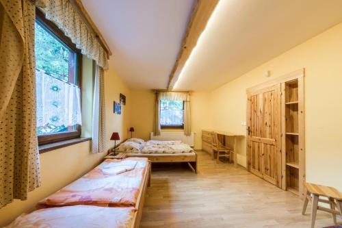 a room with two beds and a desk in it at Poráč Park in Poráč
