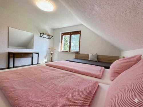 a bedroom with two beds with pink sheets at W-Apartments - Spacious Parking, EV-Station, Washer & Private Garden in Offenburg