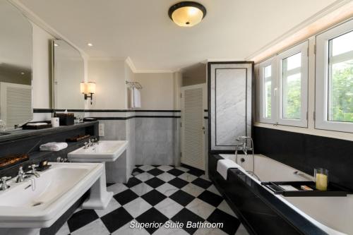 a large bathroom with two sinks and two tubs at Eastern & Oriental Hotel in George Town
