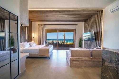 a bedroom with two beds and a balcony with the ocean at Solmare beachfront apartments in Panormos Rethymno
