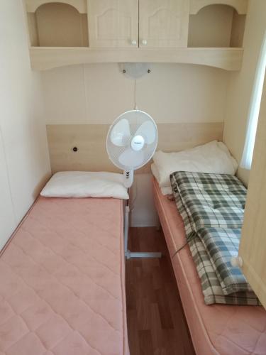 a small room with two beds and a fan at Le petit Paradis d'Hetty in Buxières-sous-Montaigut