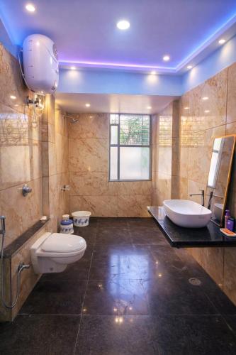 a large bathroom with a toilet and a sink at Oasis Fun Villa - Pet Friendly Cafe in Indore