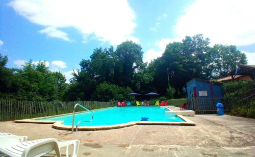 a swimming pool in a yard with a fence at Le petit Paradis d'Hetty in Buxières-sous-Montaigut