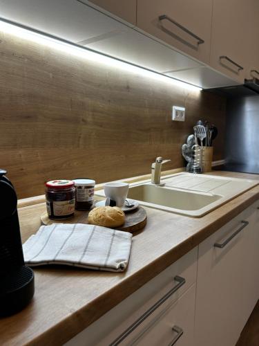 a kitchen counter with a sink and a counter top with cookies at Apartmán ESKIMO in Bystrá