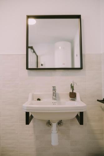 a white sink in a bathroom with a mirror at Casa Aula Minerva Sapientia 2 Habitaciones in Almedinilla