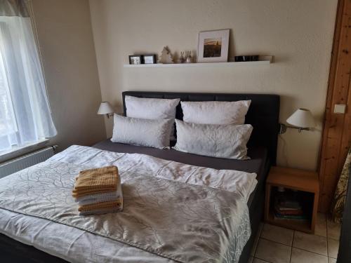 a bedroom with a bed with white sheets and pillows at Ferienwohnung Drechsel in Olbernhau
