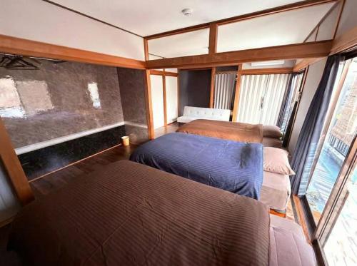 a bedroom with two beds and a window at 民泊 みづき 一棟貸し in Ibusuki