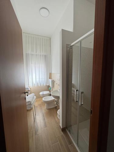 a bathroom with two toilets and a glass shower at Hotel Ammare in Sottomarina