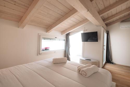 a bedroom with a large white bed with a window at City Boutique in Porto Torres