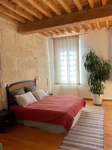 a bedroom with a bed with a red blanket and a window at Le Patio d'Arles in Arles