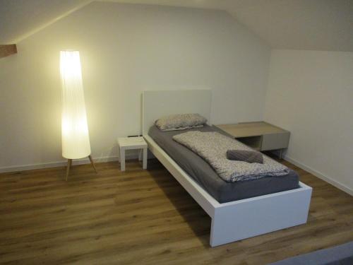 a small bedroom with a bed and a lamp at Parsberger Ferienhaus 23 a in Parsberg