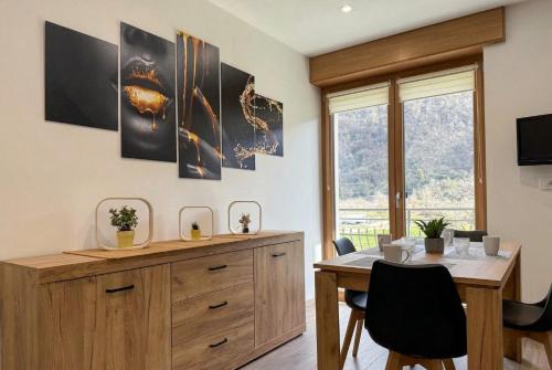 a dining room with a table and chairs and a window at Alla Rupe 8 - bilocale con vista sulle Alpi in Grosotto