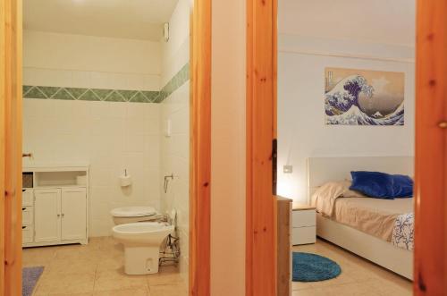 a bathroom with a bed and a toilet in a room at Home Garden in Cala Gonone