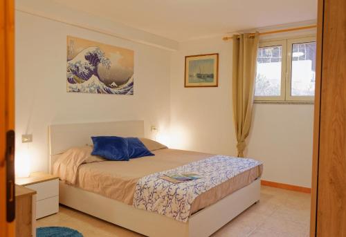 a bedroom with a bed and a painting on the wall at Home Garden in Cala Gonone