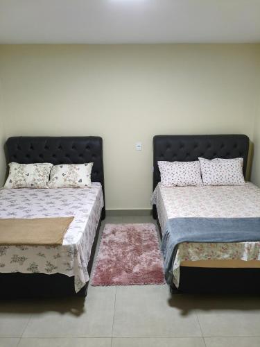 two beds sitting next to each other in a bedroom at Casa Marco in Anápolis