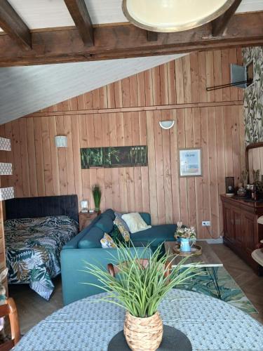 a living room with a blue couch and a table at Studio aux portes de Parthenay in Châtillon-sur-Thouet
