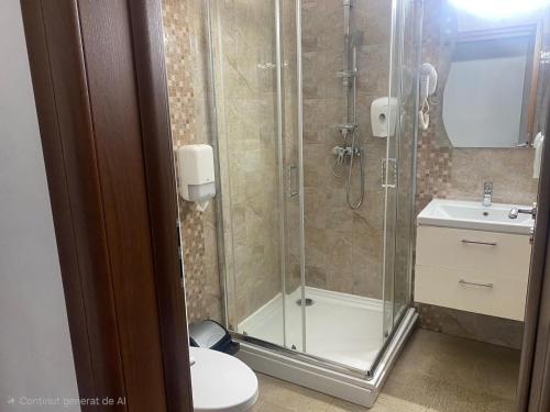 ein Badezimmer mit Dusche, Toilette und Waschbecken in der Unterkunft Hotel Ostrov in Călimăneşti