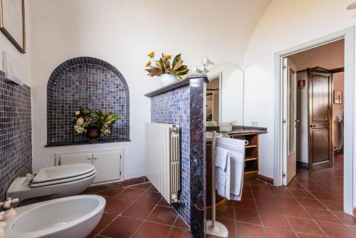 a bathroom with two toilets and a sink at Podere Magnolia in Pisa