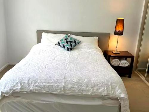 a white bed with a pillow on top of it at Oak Hill Cottage - Chirnside Park in Wonga Park