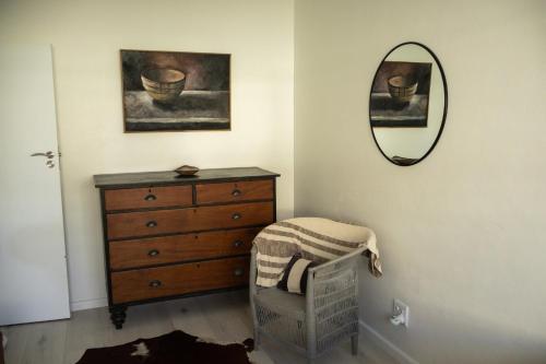 a bedroom with a dresser and a mirror at Seafront house with a view in Kleinmond