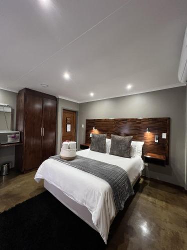 a bedroom with a large white bed with a wooden headboard at 37 On Anderson in Pretoria