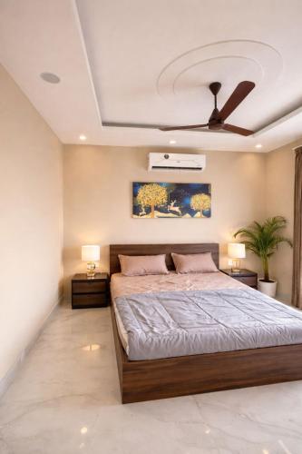 a bedroom with a large bed and two lamps at Shiv kashi farm luxury 3bhk with big pool in Noida