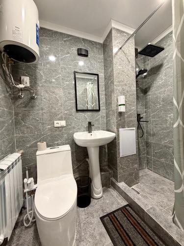 a bathroom with a toilet and a sink and a shower at Sky 28 in Almaty