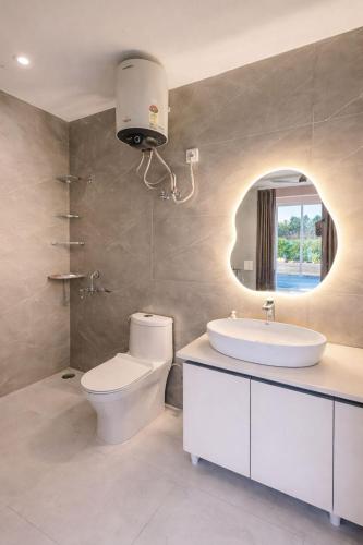 a bathroom with a toilet and a sink and a mirror at Shiv kashi farm luxury 3bhk with big pool in Noida
