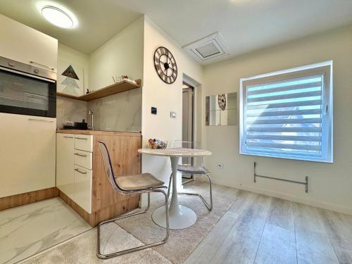a kitchen with a table and a clock on the wall at Negotin Centar Apartment with Parking in Negotin