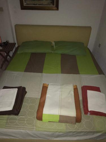 a large bed with colorful sheets and towels on it at Airy and cosy summer flat in Siviri