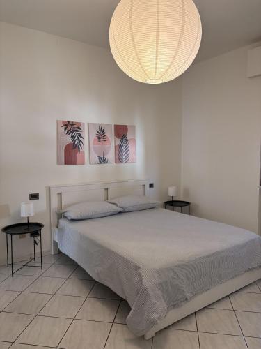 a bedroom with a large bed and a chandelier at Civico 107 in Capolona