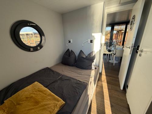 a small bedroom with a bed and a mirror at Hausboot Luft & Liebe in Halle an der Saale