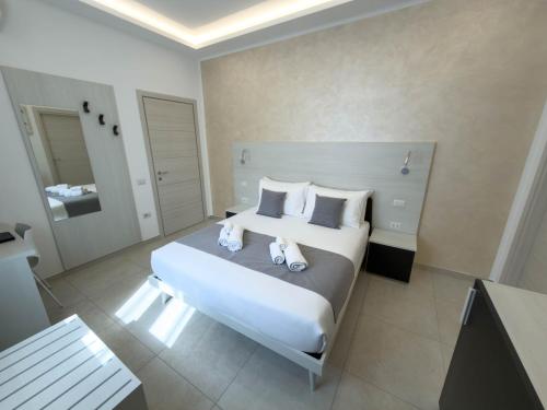 a bedroom with a large white bed with two stuffed animals on it at Cattleya Rooms in Sestu