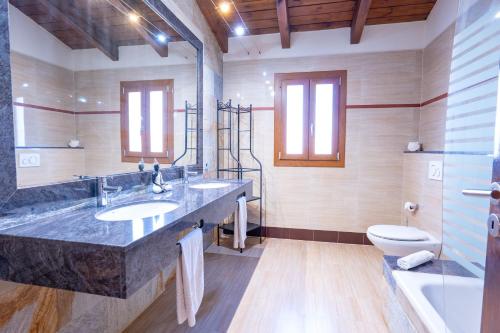 a large bathroom with two sinks and a toilet at Casa Ailen in Islas Baleares