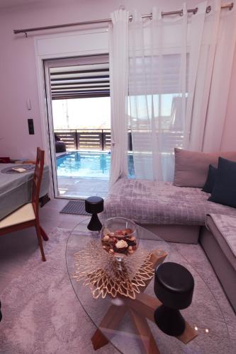 a living room with a couch and a glass table at Villa Laurela in Salamina