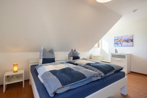 a bedroom with a bed with blue and white sheets at Haus Altburgstädtel in Dresden