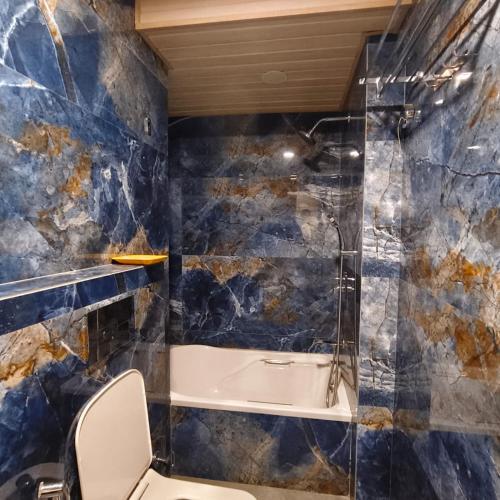 a bathroom with a toilet and a bath tub at Sienna Suites in Navi Mumbai