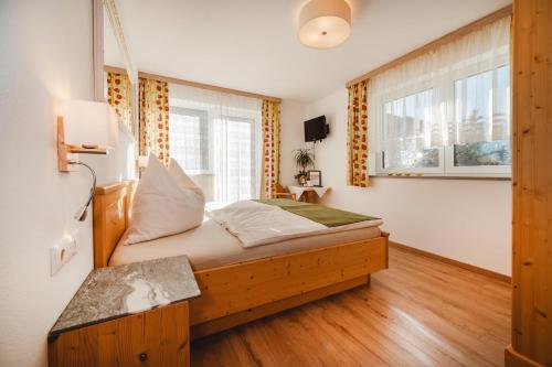 a bedroom with a wooden bed in a room at Landhaus Gerstgraser in Rauris