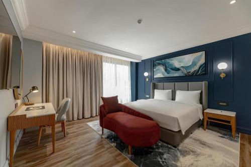 a hotel room with a bed and a red chair at Radisson Blu Hotel Lusaka in Lusaka