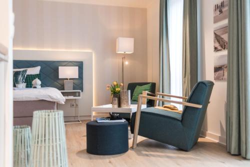 a bedroom with a bed and a chair and a table at Am Park 27 in Prerow
